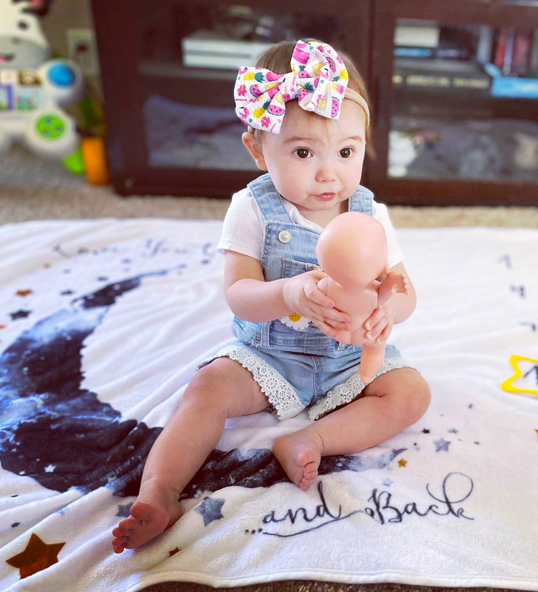 Kynlee joined the competition — help win amazing prizes! baby, baby_toddler_clothing, beanie, cap, child, facial_expression, fashion_accessory, flooring, foot, fun, happy, headband, headpiece, headwear, pattern, person, pink, play, purple, sitting