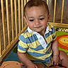 toddler, child, baby, striped_shirt, polo_shirt, sitting, playmat, playpen, wooden_bars, indoor, floor, colorful, cute, person, young_child, portrait, casual_clothing, expression, skin, hand