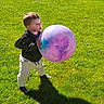 Elliot joined the competition — help win amazing prizes! toddler, child, ball, grass, outdoor, sunlight, shadow, playing, colorful, purple, blue, jacket, pants, standing, nature, daylight, young_child, toy, fun, casual_clothing