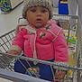 Takala is registered to the contest to win money with this photo: toddler, child, shopping_cart, pink_jacket, knitted_hat, supermarket, grocery_store, clothing, baby, person, indoor, floor, metal, retail, shopping, sitting, face, curious, holding, footwear