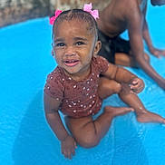 Takala joined the competition — help win amazing prizes! child, toddler, water, pool, pink_bows, happy, smiling, sitting, brown_skin, short_hair, summer, outdoor, fun, play, wet, blue, person, cute, baby_clothes, water_play