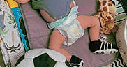 Giovani is registered to the contest to win money with this photo: baby, infant, diaper, onesie, plush_toy, soccer_ball, giraffe_toy, playmat, patterned_blanket, sleeping, cute, child, soft_toys, nursery, lying_down, footwear, colorful, indoor, relaxed, text_overlay