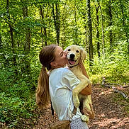 Ben a rejoint le concours — aidez-le/la à gagner de superbes lots ! bag, casual_clothing, dog, forest, greenery, happy, holding, kiss, leash, long_hair, nature, outdoor, path, pet, puppy, smile, summer, sunlight, trees, woman