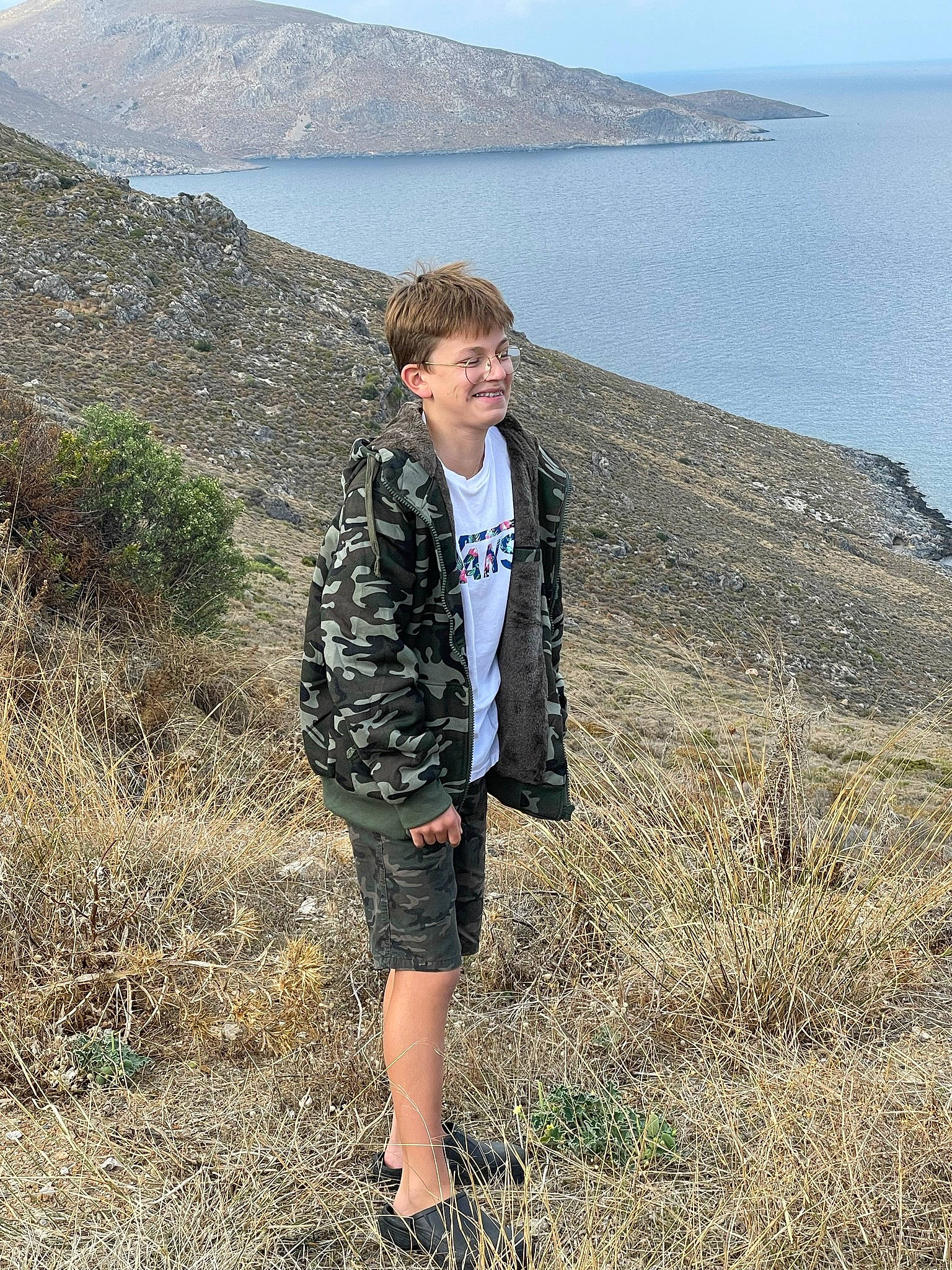 Lazare participe au concours pour gagner de l'argent avec cette photo : azure, beach, ecoregion, fun, grass, grass_family, grassland, headland, joy, lake, landscape, leisure, people_in_nature, person, rock, sand, shorts, sky, t_shirt, travel