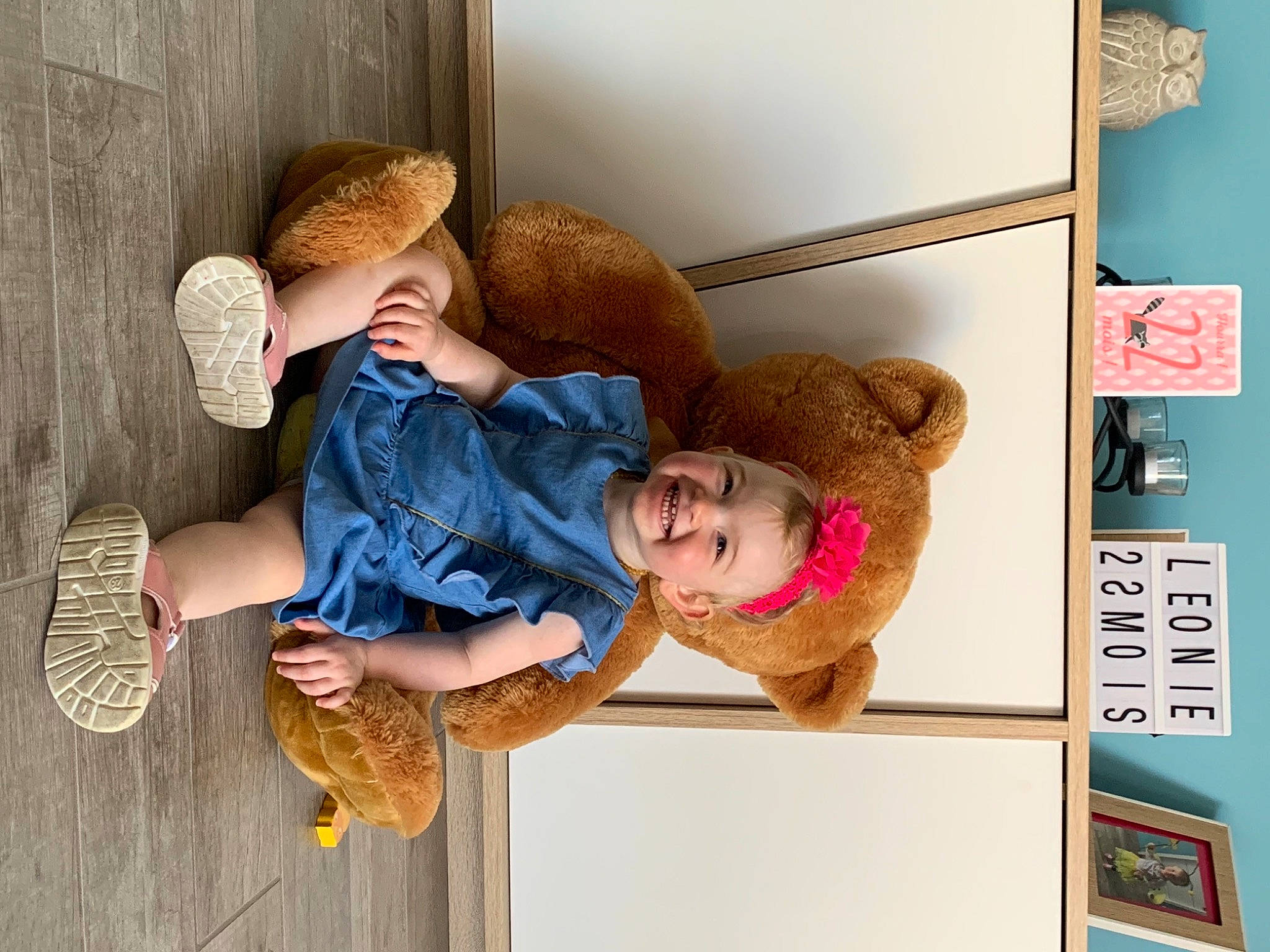 Léonie a rejoint le concours — aidez-le/la à gagner de superbes lots ! arm, child, comfort, fashion_accessory, foot, fun, happy, human_leg, joint, joy, leisure, person, room, sandal, shelf, sitting, smile, stuffed_toy, sun_hat, toddler