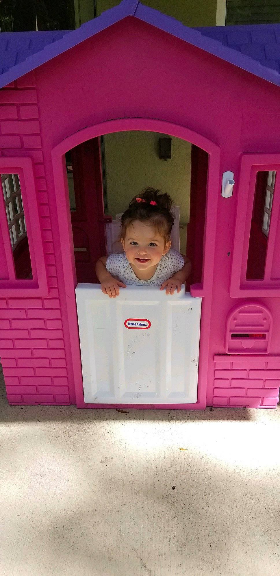 Adelaide is registered to the contest to win money with this photo: baby, baby_toddler_clothing, door, joy, magenta, material_property, person, pink, plastic, playhouse, purple, toddler