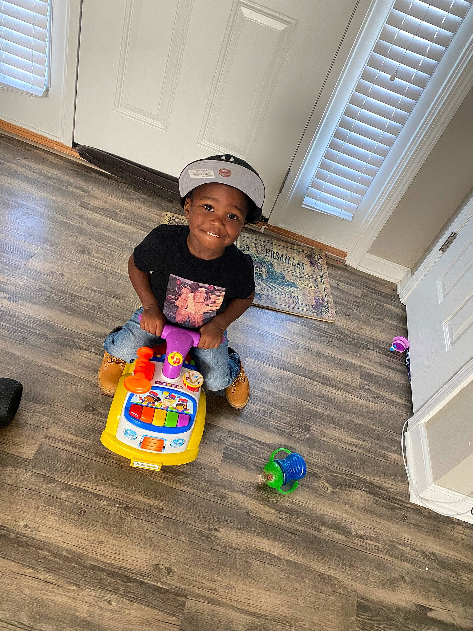 Demari joined the competition — help win amazing prizes! baby, baby_toddler_clothing, child, floor, flooring, fun, hardwood, hat, headwear, joy, laminate_flooring, person, play, room, sitting, sneakers, t_shirt, toddler, varnish, window_blind