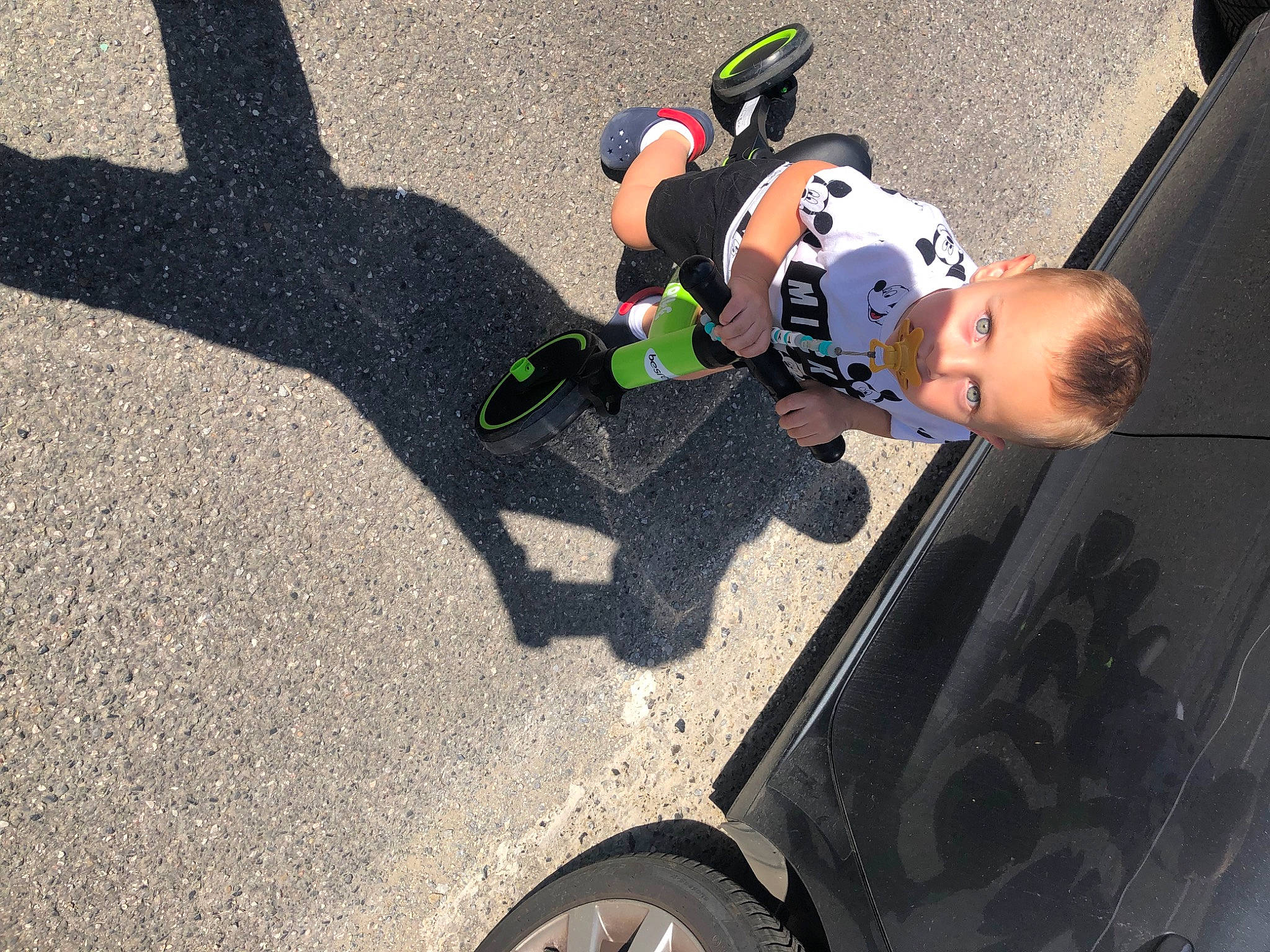 Tylian participe au concours pour gagner de l'argent avec cette photo : asphalt, auto_part, automotive_design, automotive_exterior, automotive_tire, automotive_wheel_system, fun, helmet, human_leg, motor_vehicle, person, personal_protective_equipment, road_surface, shoe, sneakers, sports_gear, tire, toddler, tree, vehicle_door