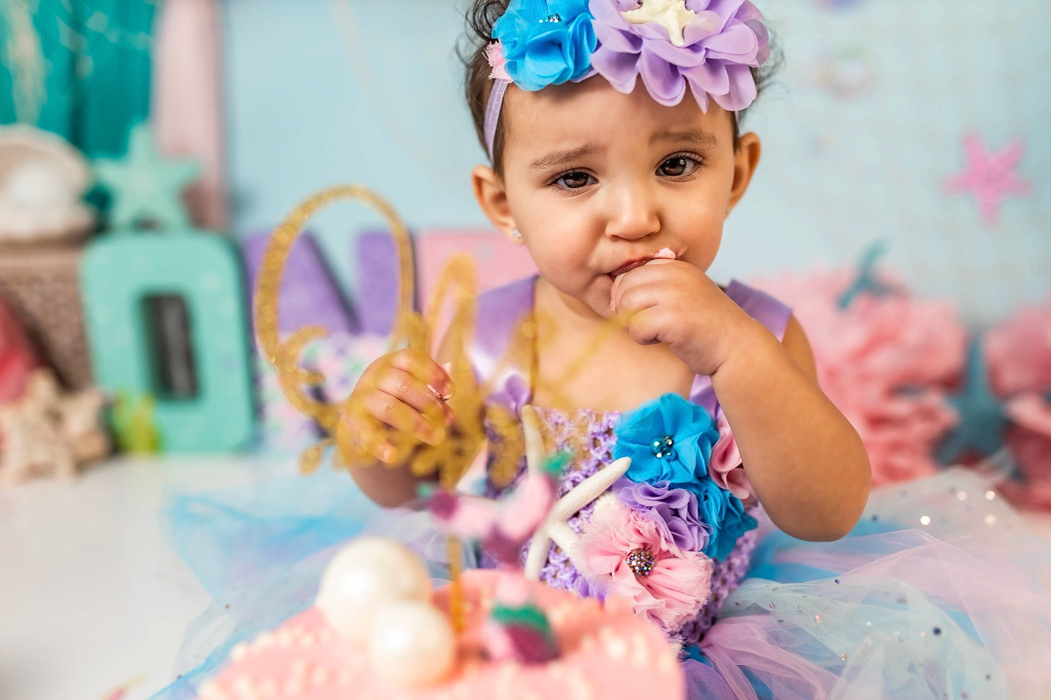 Avaleigh is registered to the contest to win money with this photo: aqua, baby, baby_toddler_clothing, cake, cake_decorating, cake_decorating_supply, clothing, dress, event, finger, food, fun, happy, headgear, headpiece, headwear, party_supply, person, pink, skin