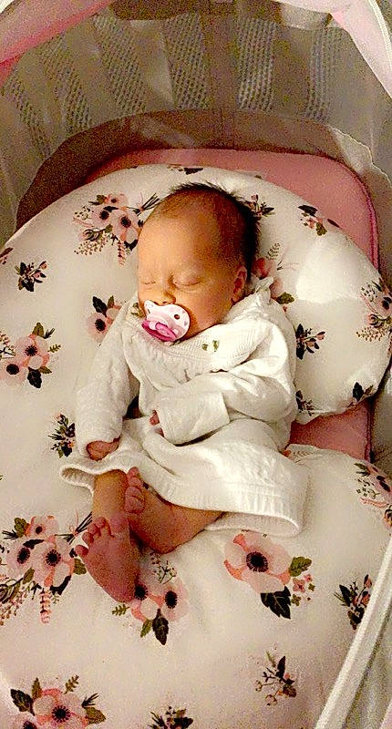 Ainsley joined the competition — help win amazing prizes! baby, baby_products, baby_safety, baby_sleeping, baby_toddler_clothing, bedding, cheek, child, comfort, linens, pattern, person, petal, pink, product, room, sitting, skin, sleeve, textile