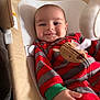 Miller is registered to the contest to win money with this photo: baby, infant, smile, face, onesie, striped_clothing, reindeer_patch, red_clothing, gray_clothing, green_cuff, baby_seat, cushion, fabric, hand, happy, indoors, portrait, cute, child, comfort