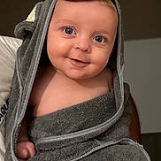 Mattéo participe au concours pour gagner de l'argent avec cette photo : baby, towel, hood, smile, blue_eyes, cute, infant, child, wrapped, cozy, happy, portrait, indoors, soft_texture, face, skin, person, young, adorable, expression