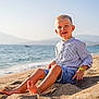 child, boy, beach, sand, sea, ocean, mountains, sunlight, casual_clothing, shorts, striped_shirt, barefoot, smiling, outdoor, summer, sunny, water, nature, portrait, relaxation