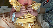 Serenityrose is registered to the contest to win money with this photo: newborn, baby, infant, sleeping, yellow_clothing, headband, blanket, hospital, bed, person, cute, soft_texture, wrapped, hand, peaceful, indoors, child, wearing, resting, toddler