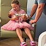 child, newborn, baby, girl, man, chair, pink_tutu, hello_kitty_slippers, hospital_room, blanket, flooring, holding, smiling, family, love, tenderness, indoor, portrait, people, seated