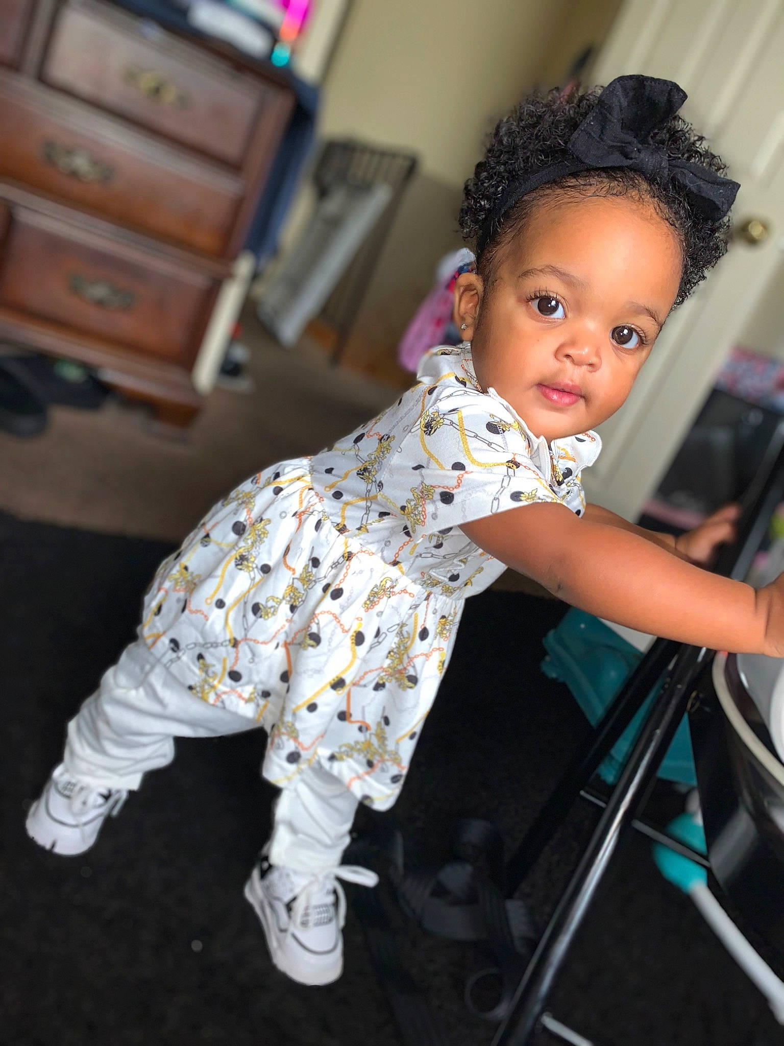 Makynzie is registered to the contest to win money with this photo: baby, baby_toddler_clothing, cabinetry, chair, chest, chest_of_drawers, child, drawer, dresser, event, fashion_design, flash_photography, flooring, fun, happy, person, purple, sitting, standing, toddler