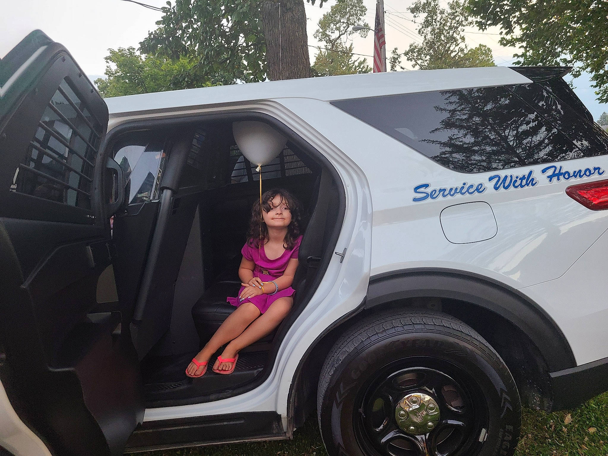 Hailey is registered to the contest to win money with this photo: alloy_wheel, automotive_design, automotive_exterior, automotive_lighting, automotive_tire, bumper, car, dress, fender, hood, motor_vehicle, person, rim, shorts, tire, tree, van, vehicle, vehicle_door, wheel