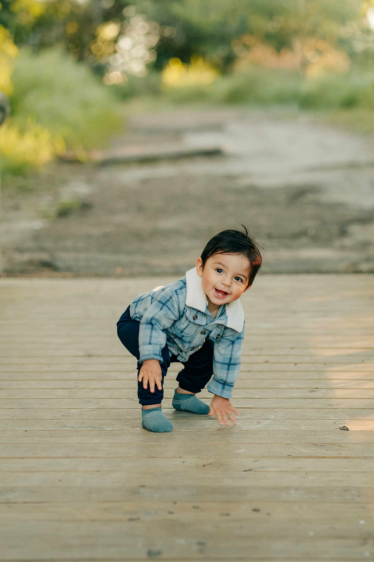 Marcello joined the competition — help win amazing prizes! toddler, child, outdoor, wooden_path, plaid_jacket, socks, smiling, crouching, happy, nature, daylight, portrait, casual_clothing, cute, young_child, playful, person, scenic, greenery, fun