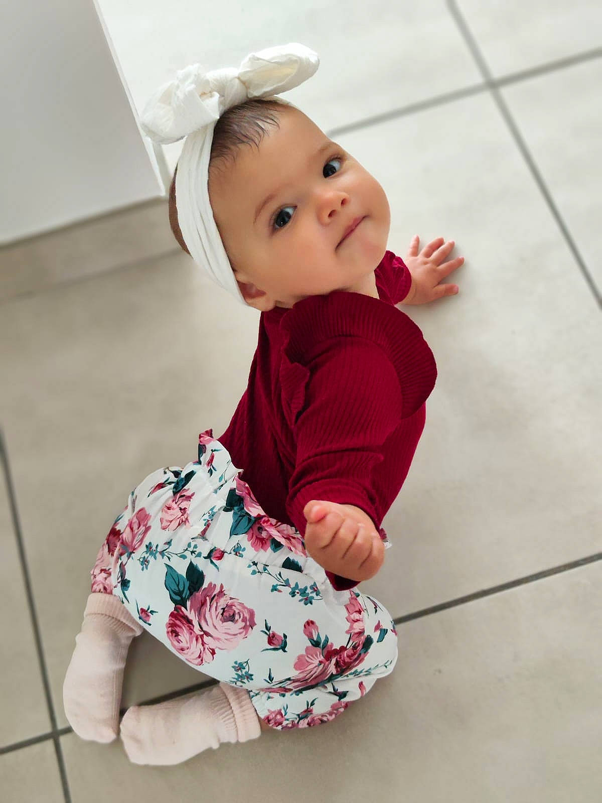 Nelya a rejoint le concours — aidez-le/la à gagner de superbes lots ! baby, baby_toddler_clothing, cheek, child, collar, dress, floor, flooring, happy, human_body, human_leg, magenta, pattern, person, pink, sitting, skin, sleeve, standing, toddler