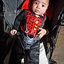 baby, child, stroller, costume, vampire, cape, red, black, straps, seat, wide_eyes, curious, infant, person, cute, portrait, indoors, clothing, baby_seat, expression