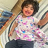 Ella joined the competition — help win amazing prizes! toddler, child, smiling, happy, indoor, rug, dress, cartoon_print, black_pants, hair, face, person, playful, cute, socks, floor, patterned_rug, wooden_floor, cozy, joyful