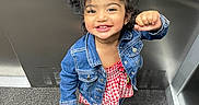 Ella is registered to the contest to win money with this photo: toddler, child, smiling, denim_jacket, pigtails, elevator, carpet, indoor, happy, person, cute, fashion, footwear, red_and_white, checkered, playful, standing, casual_wear, victory_pose, young