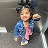 toddler, child, smiling, denim_jacket, pigtails, elevator, carpet, indoor, happy, person, cute, fashion, footwear, red_and_white, checkered, playful, standing, casual_wear, victory_pose, young