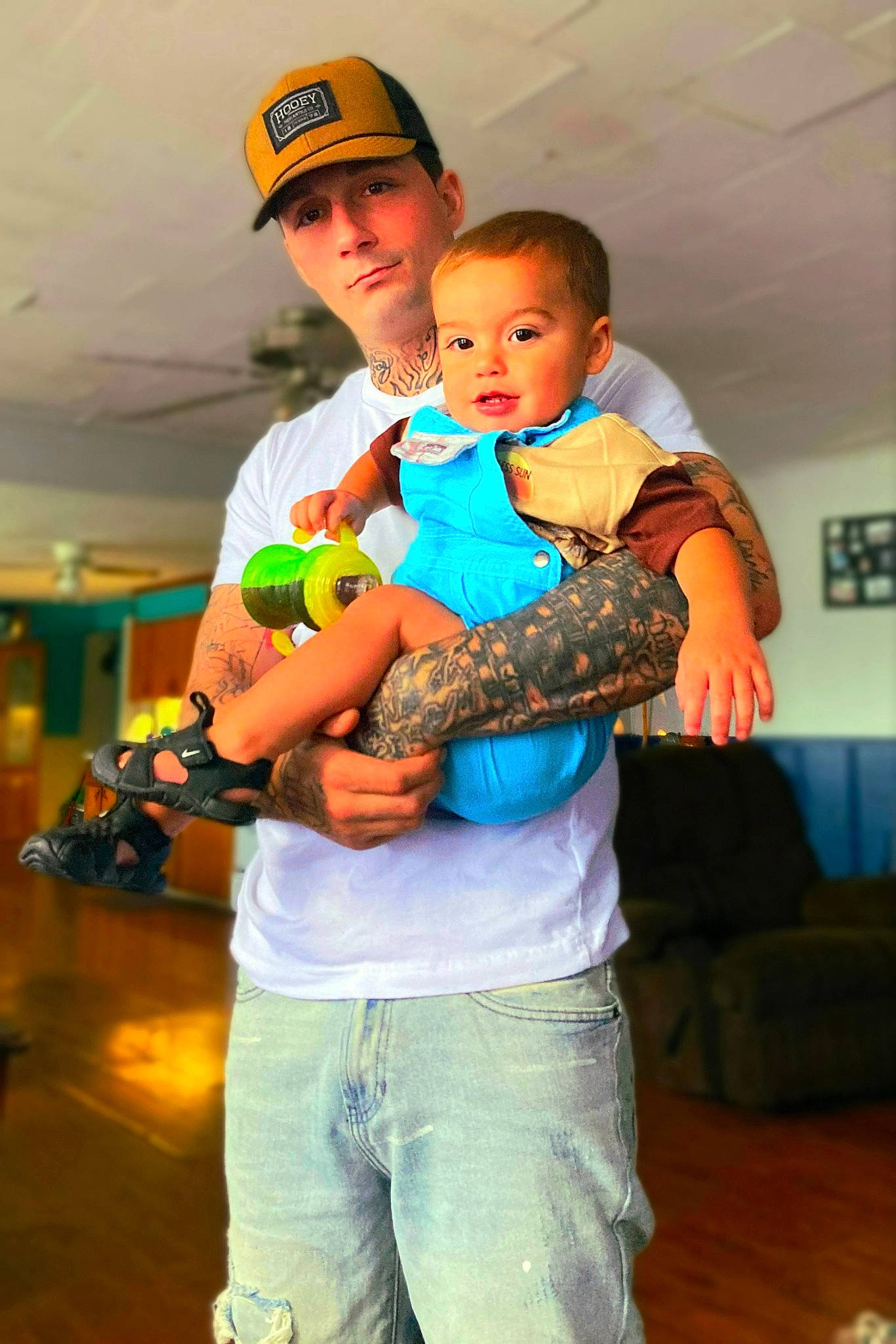 Jason is registered to the contest to win money with this photo: abdomen, baby, baseball_cap, cap, child, couch, electric_blue, event, fun, happy, headwear, hug, jeans, leisure, person, recreation, room, stuffed_toy, t_shirt, toddler