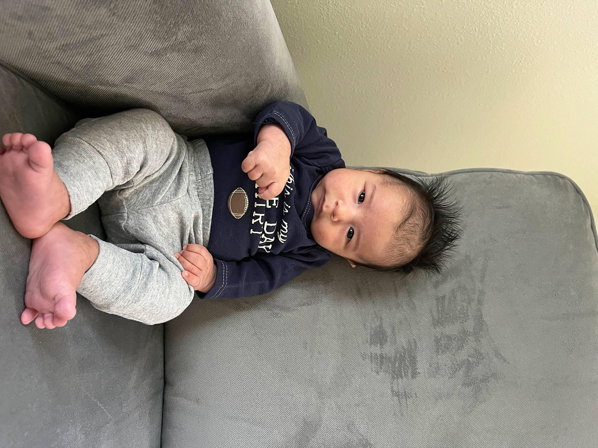 Lionel is registered to the contest to win money with this photo: baby, baby_toddler_clothing, comfort, couch, flash_photography, flooring, foot, grey, human_body, human_leg, knee, leg, linens, person, sitting, skin, sleeve, textile, thigh, toddler