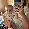 Rylan joined the competition — help win amazing prizes! adult, baby, bedroom, blanket, child, clothing, curtains, holding, home, indoor, infant, mirror, onesie, parent, portrait, selfie, serious_expression, smartphone, sneakers, wooden_wall