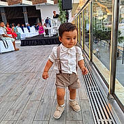 Alessio a rejoint le concours — aidez-le/la à gagner de superbes lots ! toddler, child, boy, walking, shorts, suspenders, white_shirt, shoes, outdoor, event, people, seated, glass_railing, reflection, mountains, cityscape, wooden_floor, daylight, curious, cute