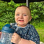 baby, child, smiling, blue_eyes, sippy_cup, outdoor, greenery, umbrella, happy, tooth, clothing, short_sleeves, nature, table, person, infant, cute, face, hand, daylight