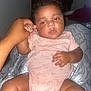 Unique joined the competition — help win amazing prizes! baby, child, infant, hand, onesie, pink_clothing, patterned_blanket, indoor, person, skin, face, legs, seated, holding_hand, curly_hair, resting, cute, sleepy, comfort, toddler