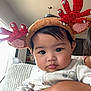 baby, child, reindeer_headband, holiday, festive, cute, indoor, person, face, hand, clothing, arm, looking, expression, cozy, holiday_accessory, infant, holding, cute_outfit, portrait