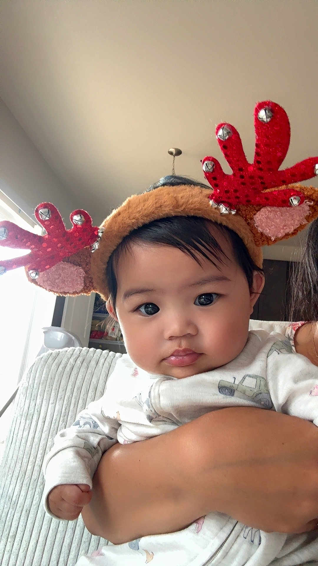 Maliah is registered to the contest to win money with this photo: baby, child, reindeer_headband, holiday, festive, cute, indoor, person, face, hand, clothing, arm, looking, expression, cozy, holiday_accessory, infant, holding, cute_outfit, portrait