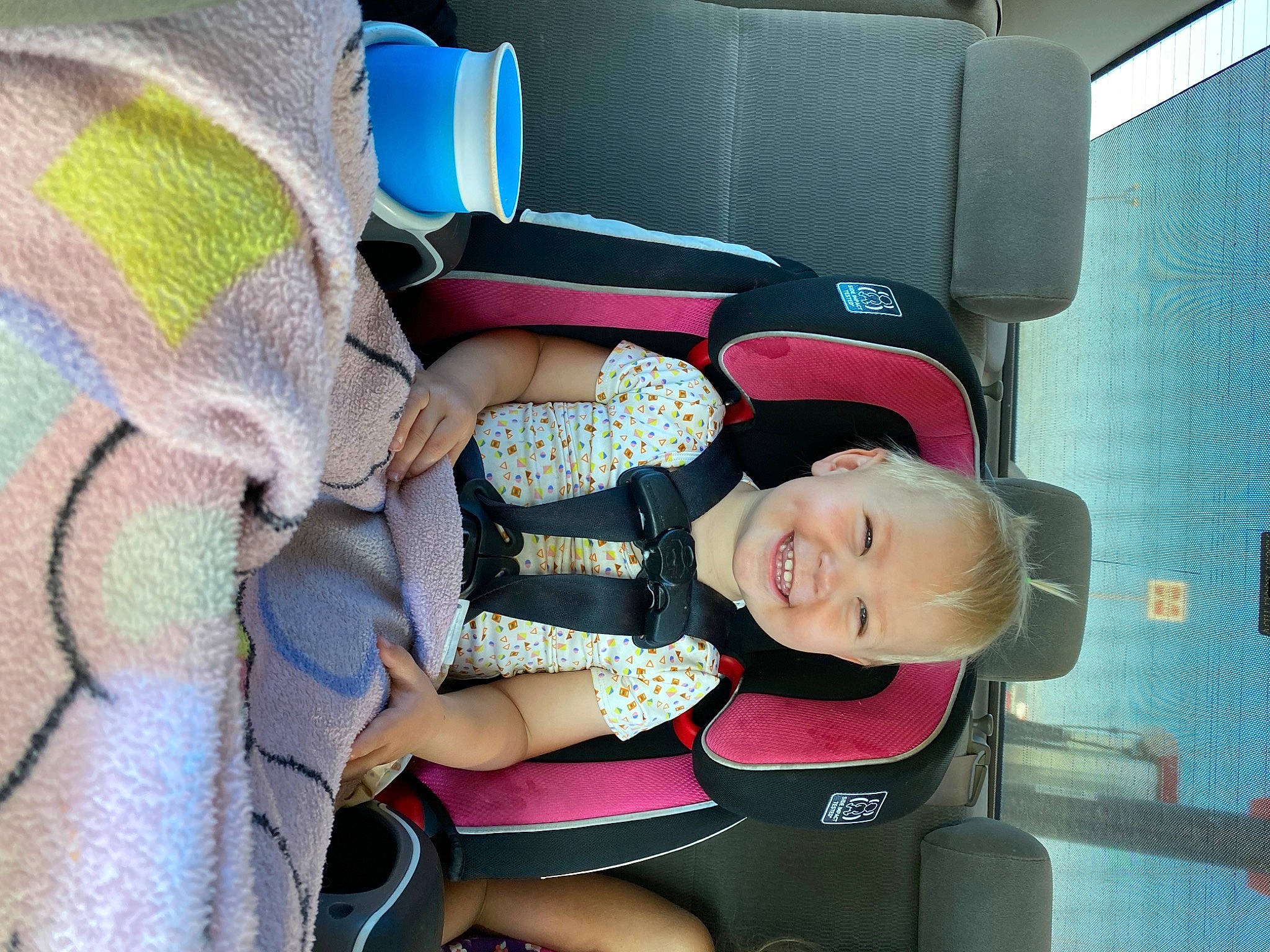Bexley is registered to the contest to win money with this photo: auto_part, baby_carriage, baby_products, baby_toddler_clothing, car_seat, car_seat_cover, child, comfort, electric_blue, fun, joy, magenta, motor_vehicle, person, product, seat_belt, sitting, smile, steering_wheel, toddler