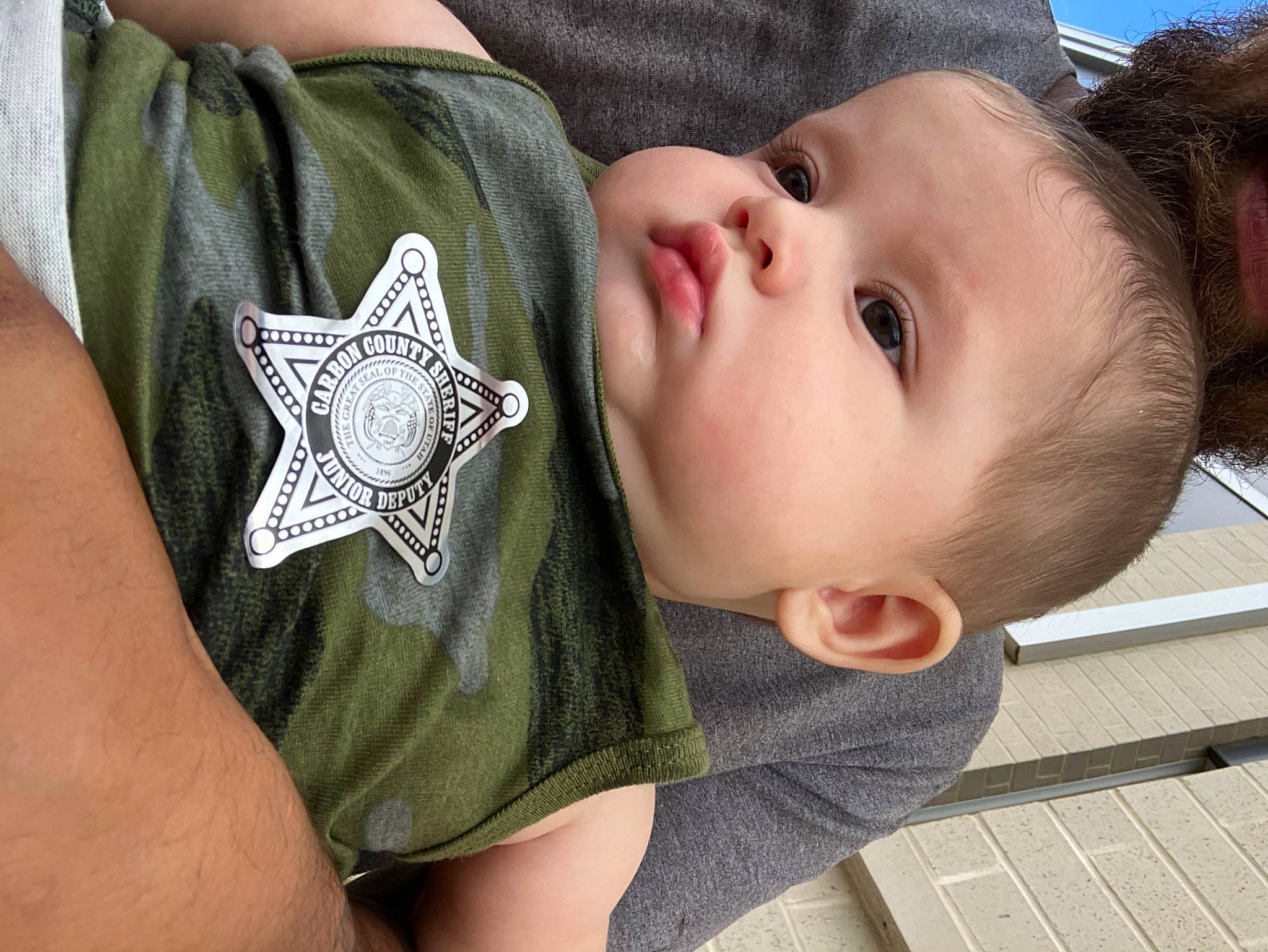 Julian is registered to the contest to win money with this photo: baby, baby_products, baby_toddler_clothing, cheek, chest, child, elbow, eyelash, fashion_accessory, grass, happy, nose, pattern, person, skin, sleeve, thumb, toddler, tree, wood