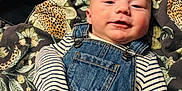 Teddy is registered to the contest to win money with this photo: baby, infant, denim_overalls, striped_shirt, smile, face, blanket, patterned_blanket, leopard_print, leaves, clothing, child, cute, portrait, lying_down, indoors, soft_light, happy, young_child, casual