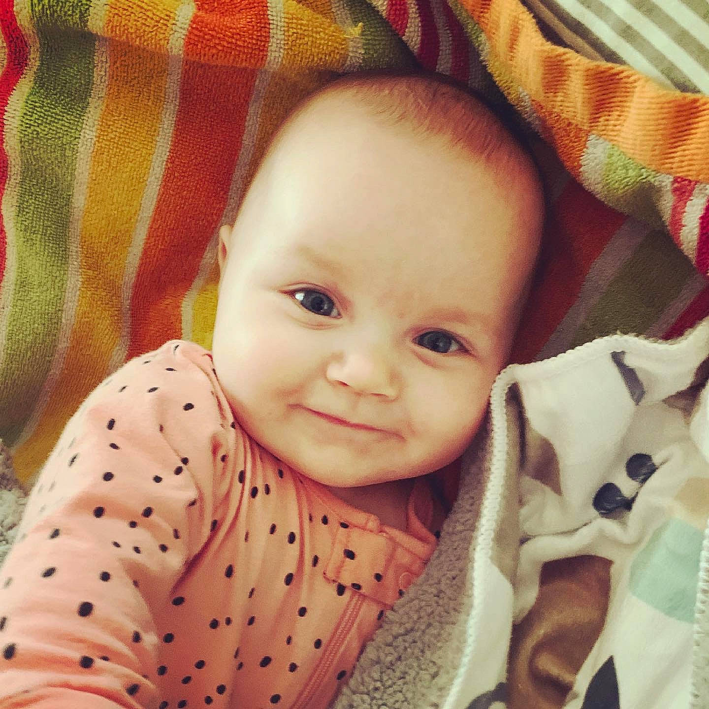 Sloane is registered to the contest to win money with this photo: baby, baby_toddler_clothing, cheek, chin, comfort, eye, eyebrow, face, facial_expression, happy, human, human_body, iris, lip, nose, outerwear, person, skin, sleeve, smile