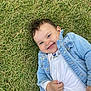 baby, child, grass, smiling, denim_jacket, white_shirt, happy, outdoor, cute, young_child, portrait, nature, playful, person, casual_clothing, face, head, skin, baby_girl, lying_down