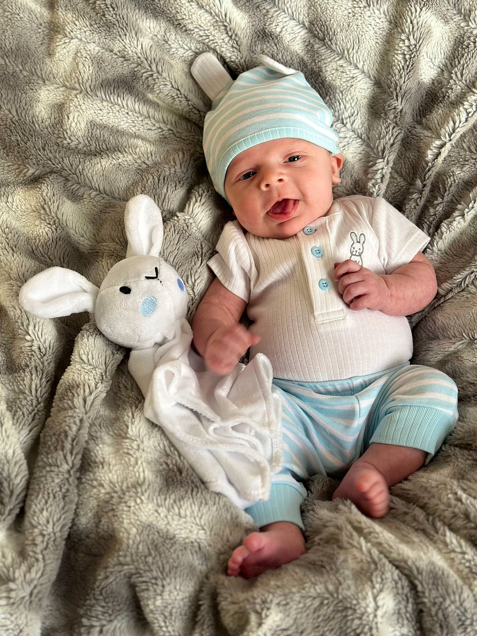 Kasin joined the competition — help win amazing prizes! baby, baby_toddler_clothing, cap, comfort, finger, foot, gesture, hand, happy, headwear, leg, linens, person, pink, sitting, skin, sleeve, smile, toddler, white