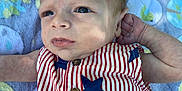Kingston Ditoro joined the competition — help win amazing prizes! baby, infant, face, clothing, striped, stars, blanket, pattern, blue, red, white, button, arm, skin, head, eyes, portrait, laying, child, cute