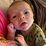 Kingston Ditoro is registered to the contest to win money with this photo: baby, infant, face, hand, clothing, patterned_shirt, pink, yellow, sunflower, expression, curious, closeup, skin, person, young_child, portrait, indoor, soft_light, couch, blanket