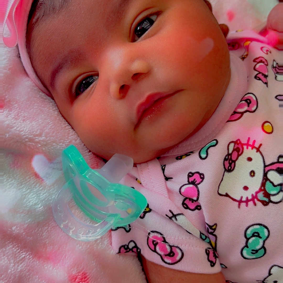 Elaini is registered to the contest to win money with this photo: baby, infant, headband, pink_bow, pacifier, hello_kitty, blanket, soft_texture, cute, child, clothing, lying_down, face, portrait, indoors, sleepwear, adorable, newborn, resting, toddler