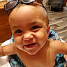 baby, child, smiling, high_chair, sunglasses, indoor, face, happy, cute, infant, person, cheerful, headwear, young_child, wooden_floor, table, blue, skin, eyes, mouth