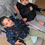 Kylian a rejoint le concours — aidez-le/la à gagner de superbes lots ! child, children, stroller, jacket, smile, indoor, floor, doorway, pants, shoe, happy, face, person, young, cute, seated, bundle_up, cozy, expression, home