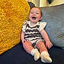 baby, child, smiling, sitting, couch, cushion, yellow_cushion, blue_couch, happy, indoor, sock, knitwear, person, face, head, furniture, cozy, home, cute, infant