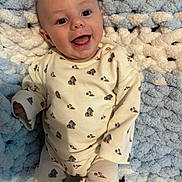 Hudson is registered to the contest to win money with this photo: baby, smiling, pajamas, infant, blanket, blue, white, cute, happy, lying_down, face, child, young, cozy, soft, patterned_clothing, indoors, portrait, cute_expression, small