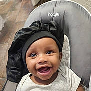 Ky'Lyn is registered to the contest to win money with this photo: baby, smiling, infant, face, headwear, bonnet, clothing, indoor, child, seat, happy, cute, person, portrait, sitting, skin, eyes, mouth, expression, baby_chair
