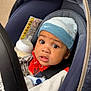 baby, car_seat, hat, bottle, clothing, child, face, eyes, expression, infant, jacket, person, seatbelt, baby_bottle, indoors, portrait, cute, young_child, headwear, sitting